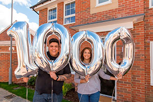 Karla Wilson and Jeremy Atkin-Smith outside their new Milton Keynes home with 1,000th resident balloons