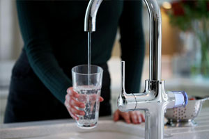 A woman using The new Smart Kitchen Tap from Bristan