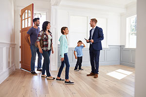 Estate agents showing a family around a new home